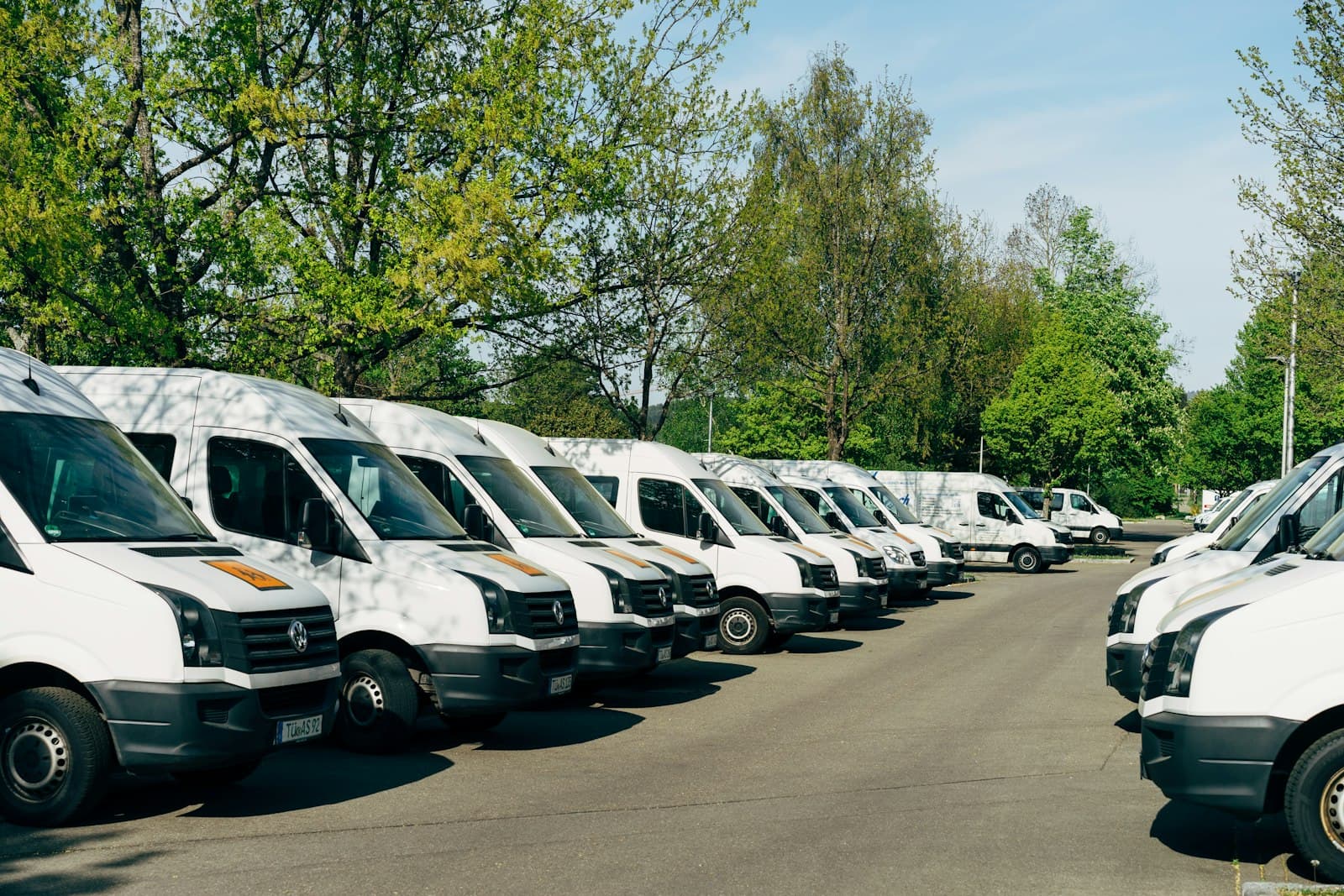 Reihe weißer Transporter auf einem Parkplatz